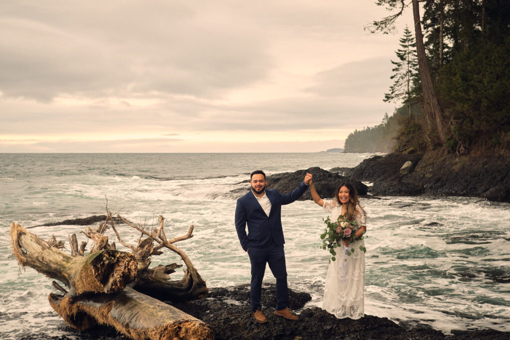 A couple cheers after saying their vows on the rocky washington coast