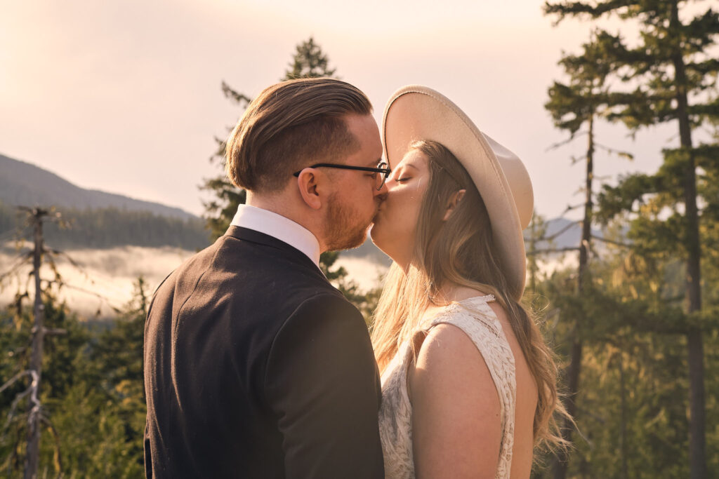 an eloping couple shares their first kiss in front of mt rainier