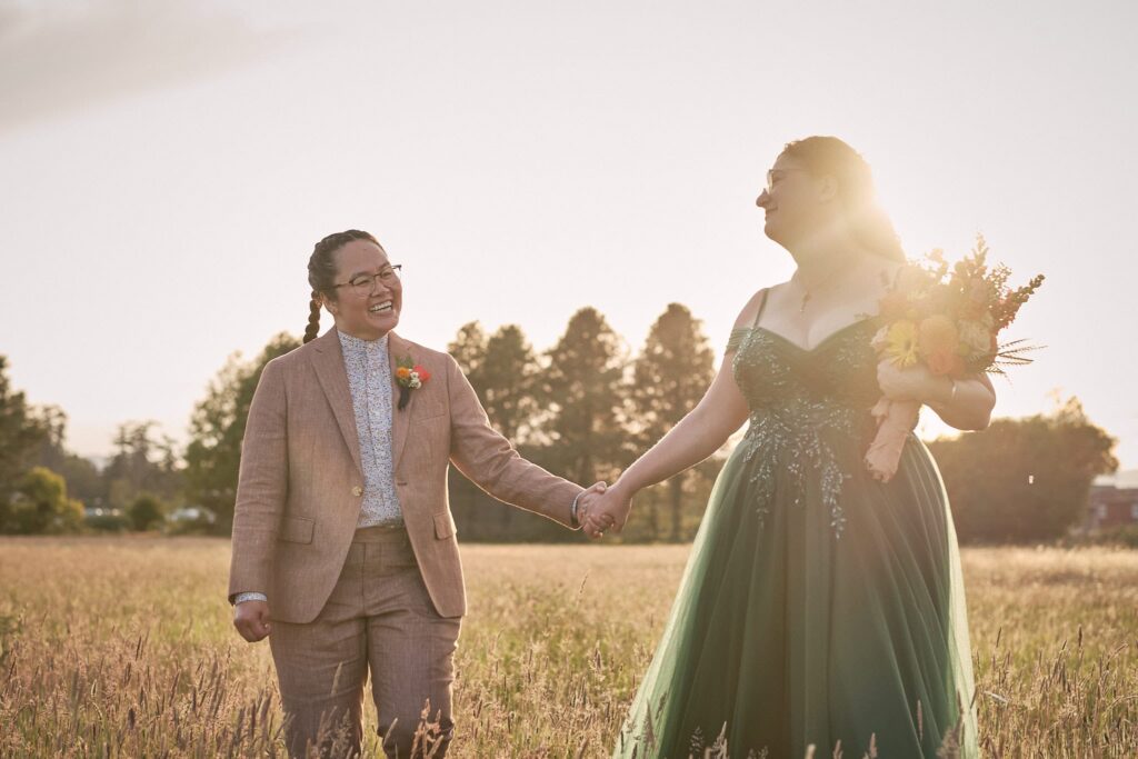 two brides frolic in a field