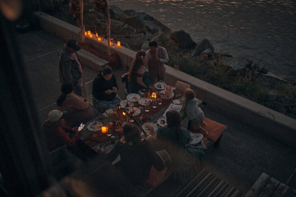 friends gather around a table after sunset