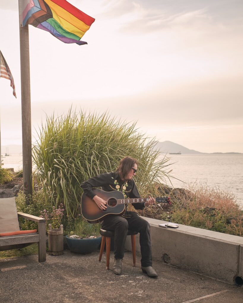 A friend plays acoustic guitar as the bride walks down the aisle