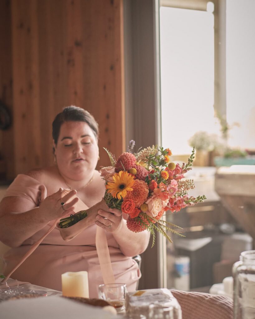 a friend wraps a bridal bouquet