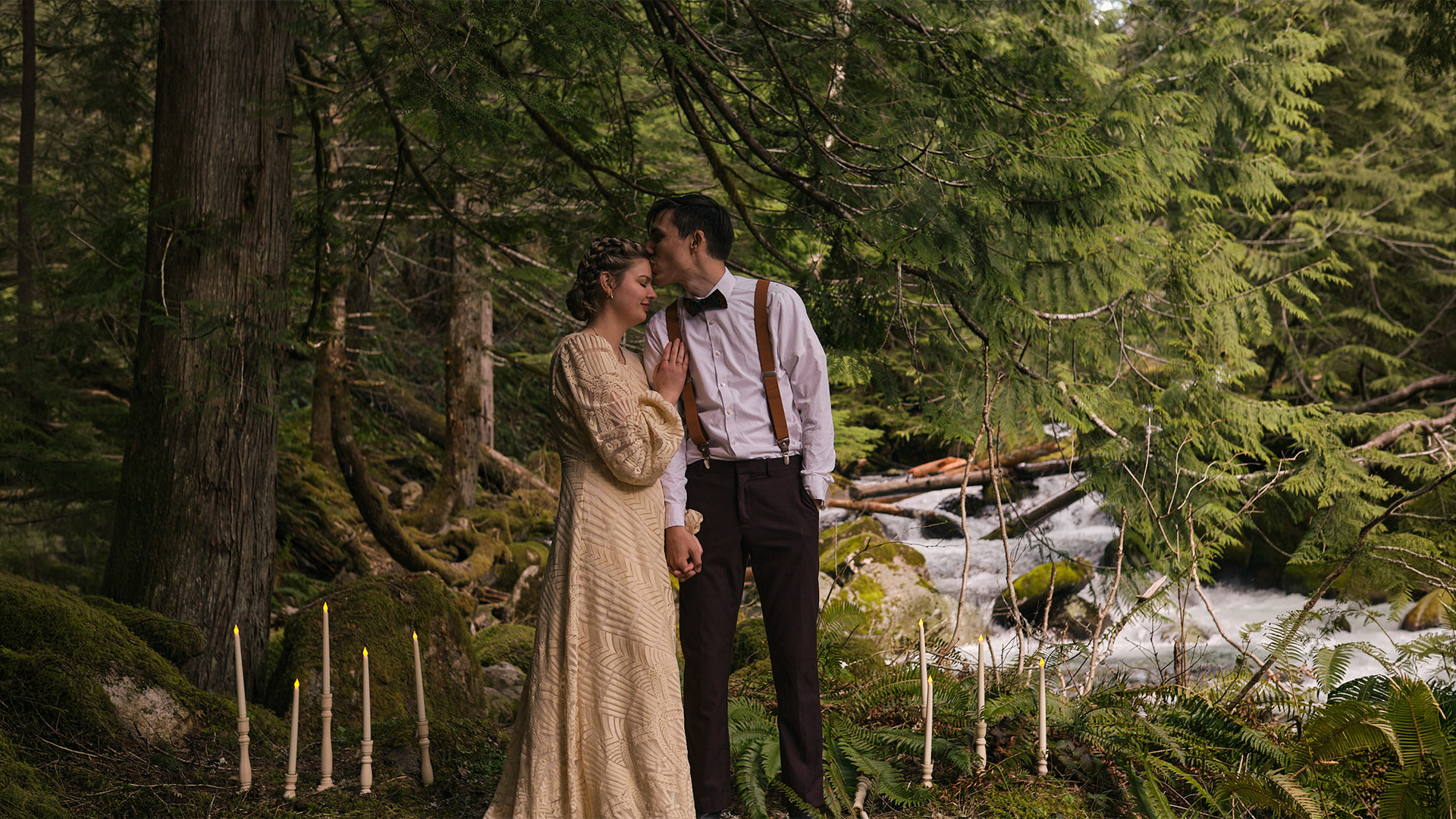a bride and groom surrounded by fake candles in the woods of Mt Rainier National Park
